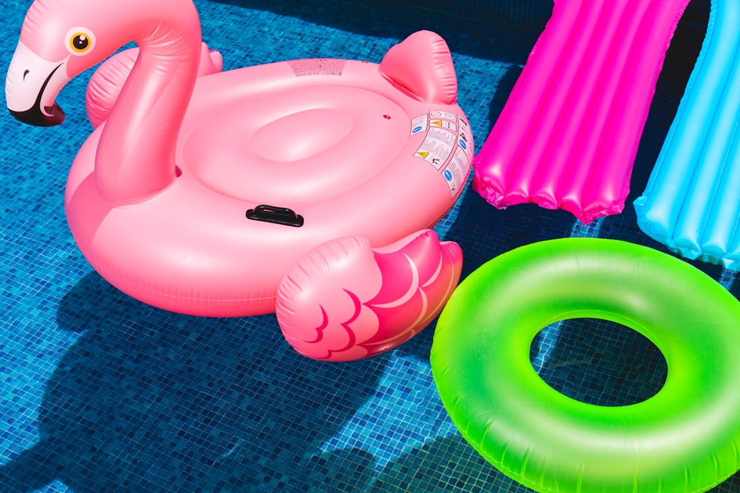 Photo by Toni Cuenca pink inflatable flamingo and green inflatable ring