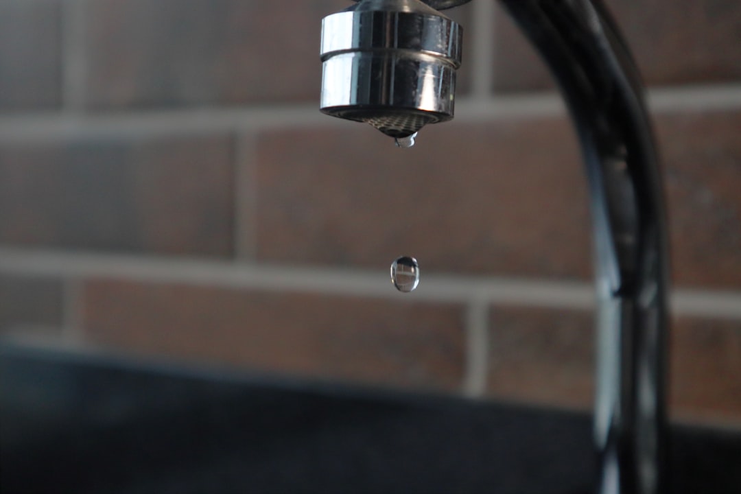 Photo by João Paulo Carnevalli de Oliveira a faucet with a water drop hanging from it