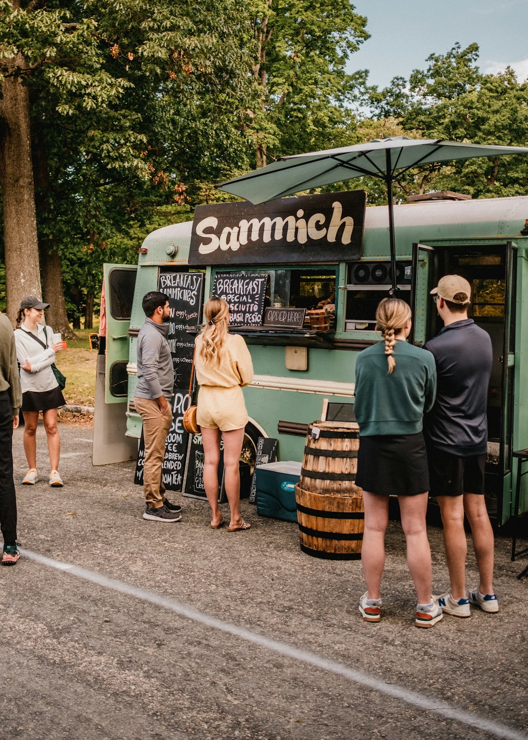 Photo by Kyle Nieber a group of people standing outside of a food truck