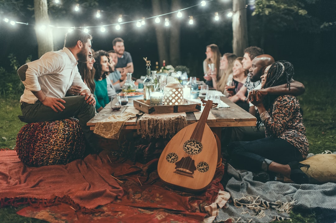 Photo by Considerate Agency people sitting on chair in front of table with candles and candles