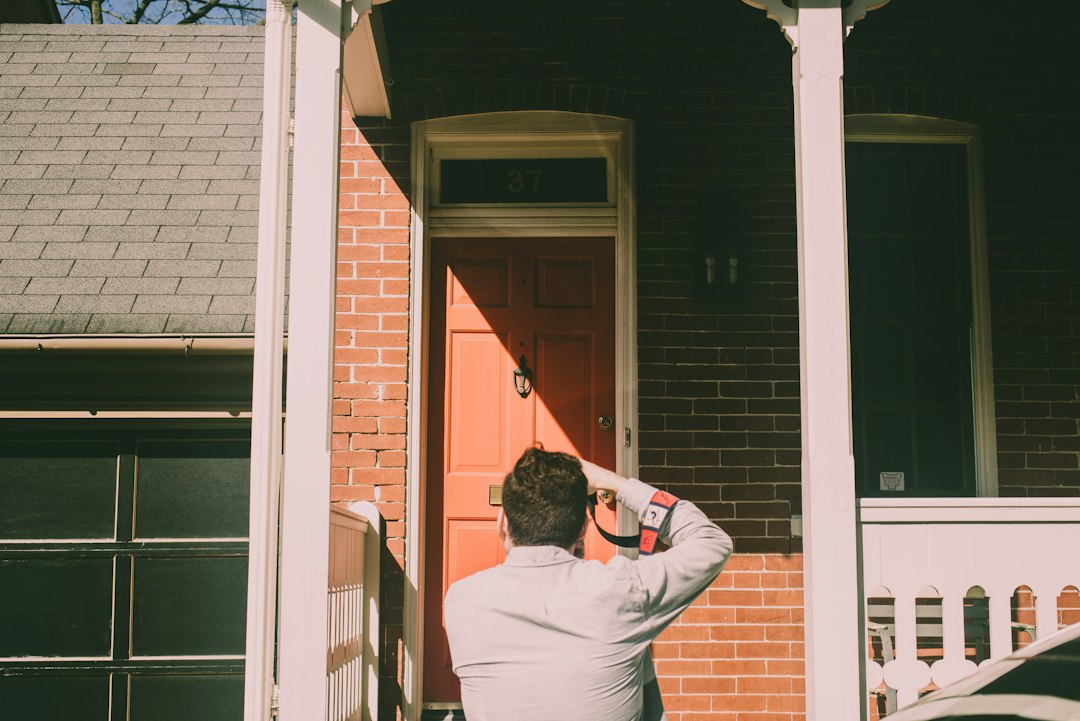 Photo by Roman Denisenko a person standing in front of a red door